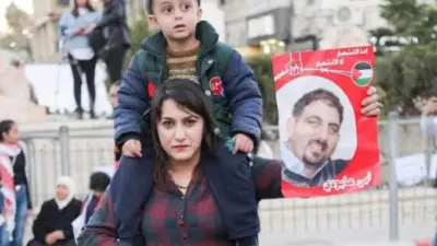 Vrouw van Ubai Aboudi tijdens manifestatie voor zijn vrijlating